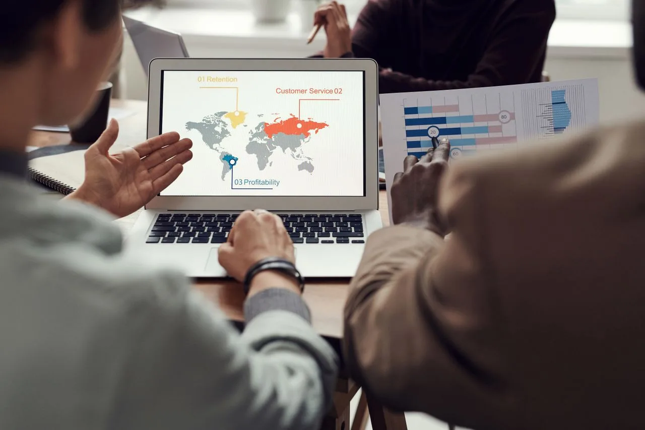 Team bespreekt bedrijfsstrategie rond een laptop met wereldwijde analyses