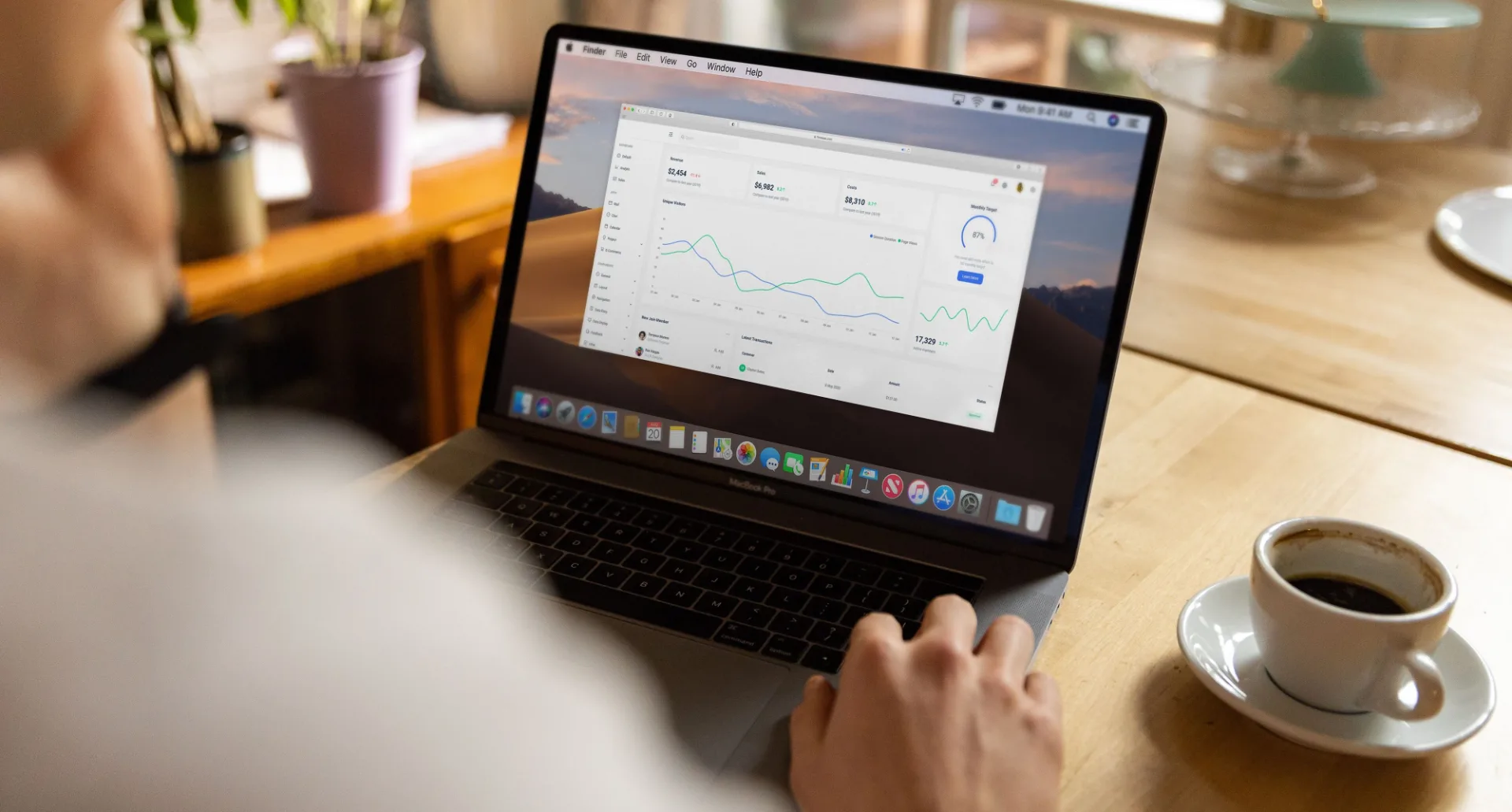 Person working on a laptop that shows a graph while reviewing business tasks